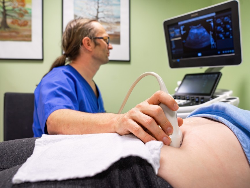 Oberarzt Lars Geerdts von der Klinik für Kinder- und Jugendmedizin bei der Ultraschalluntersuchung eines Kindes.